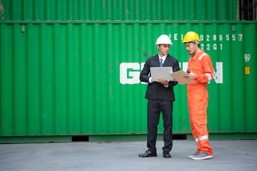 The young Executive visits the container storage yard to inspect the work with the Foreman. Transportation and industry concepts.
