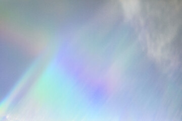 Blurred rainbow light refraction texture overlay effect for photo and mockups. Organic drop diagonal holographic flare on a white wall. Shadows for natural light effects