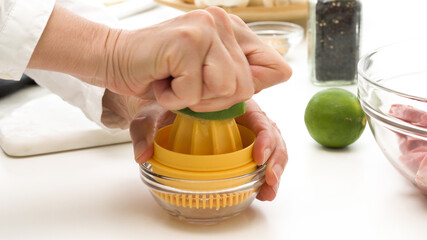 Fresh-squeezed lemon juice. Chef squeezing lemon with a mechanical citrus juicer