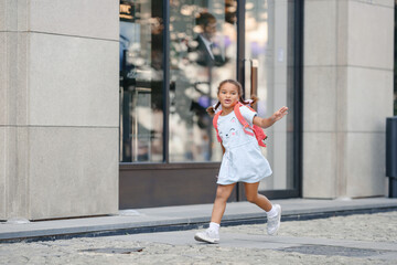 Funny little girl having fun in the city.