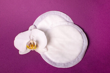 Fototapeta na wymiar Cotton breast pads on the violet background. Disposable nursing pad.