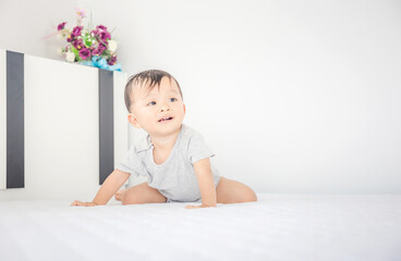 Fototapeta premium Portrait of a crawling little baby boy on the bed, Kids playing and Happiness concept