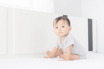 Portrait of a crawling little baby boy on the bed, Kids playing and Happiness concept