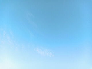 Clear blue sky with some thin clouds. Gradient blue-white background.