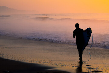 Silhoette Surfer on a misty beach in Chiba Japan with a stunning sunrise and waves. Lifestyle,surfboard,surfing,Japansurf