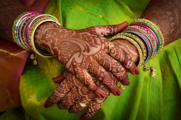 Beautiful hands of Indian bride with mehndi and bangles . Portrait of Indian wedding ceremony.