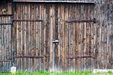 A wooden door of an old barn in a farm under the sunlight at daytime