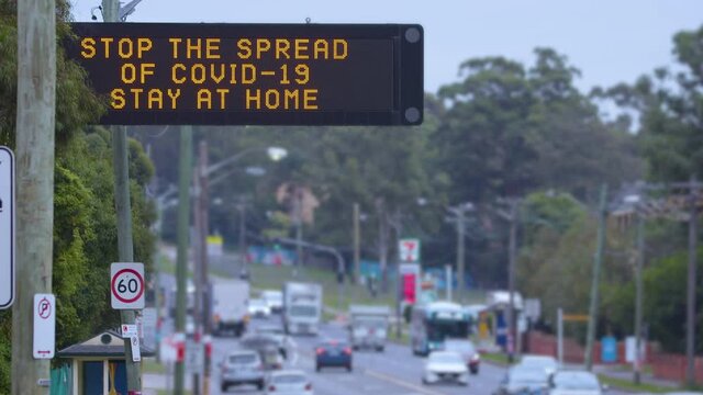 Road sign saying "Stop the spread of covid-19, stay at home."