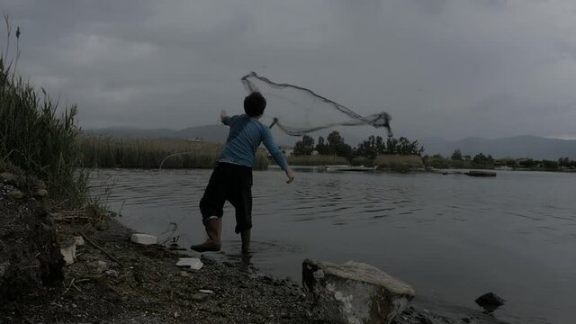 fisherman throwing fishing net   cast net catch fish by seaside fethiye turkey