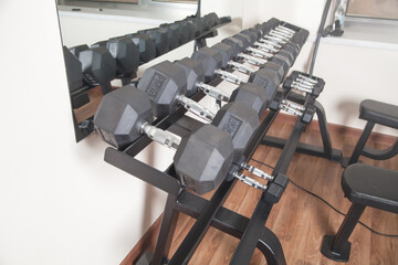 Metal dumbbells for strength training in gym.