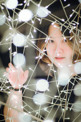 Portrait soft focus Beautiful cute young Asian Thai woman looking at camera decorated with glowing light and bokeh.