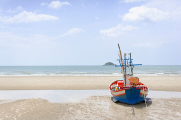 The fishing boat is parked by the blue sea at Hua Hin ,Thailand. Good for postcard or background.
