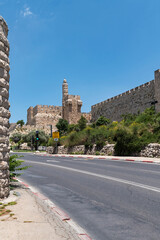 Fototapeta na wymiar the tower of david and the ancient ottoman walls of the old city of jerusalem stand next to an empty street during the time of covid-19
