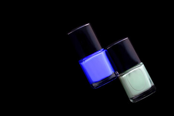 Nail polish bottles on black background, top view. With copy space. Manicure art cosmetic tools