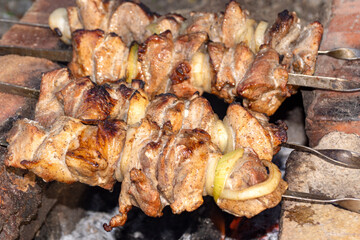 Juicy skewers in nature skewers on skewers on charcoal grilled. Barbecue. Dinner.