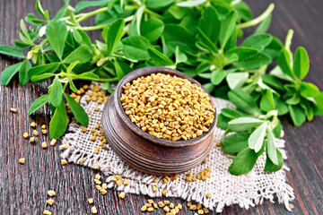 Fenugreek in bowl with leaves on dark board