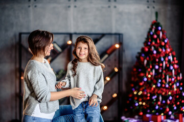 Mother and Child Hug in Front of a Christmas Tree.