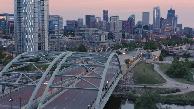 Aerial: Downtown Denver & Speer blvd bridge over the South Platte River at sunset. Colorado, USA
