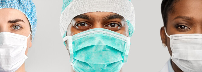 medicine, profession and healthcare concept - close up of doctor's faces in masks over grey background - Powered by Adobe