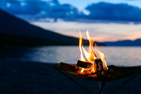 夕暮れの湖畔で焚き火とともに過ごす時間