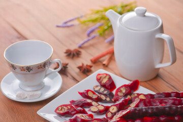 Tasty oriental sweets. Caucasian delicacy churchkhela - georgian nut treats. Served with a glass of tea and a tea pot.
