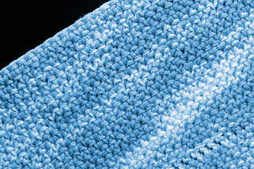 Crocheted fragment of melange yarn close-up. Handmade concept. Abstract background blue color toned