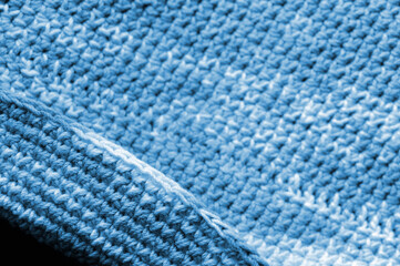 Crocheted fragment of melange yarn close-up. Handmade concept. Abstract background blue color toned