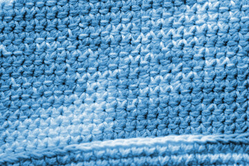 Crocheted fragment of melange yarn close-up. Handmade concept. Abstract background blue color toned