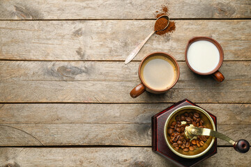 Hot coffee, milk and grinder on wooden background