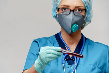 medical doctor nurse woman wearing protective mask and gloves - holding virus blood test tube