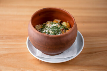 Beef meat stewed with potatoes, cheese and spices, goulash. Potato stew in ceramic bowl.