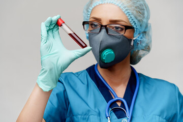 medical doctor nurse woman wearing protective mask and gloves - holding virus blood test tube