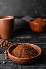 Bowl with coffee powder and beans on table