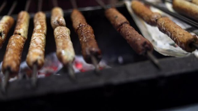 Close up of Mutton Seekh Kabab / Chicken being barbecued on charcoal grill at Chawla Kabab Roll Wale in Tilak Nagar, Delhi