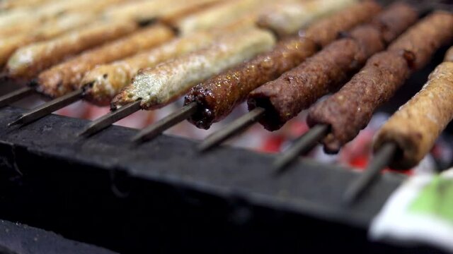 Close up of Mutton Seekh Kabab / Chicken being barbecued on charcoal grill at Chawla Kabab Roll Wale in Tilak Nagar, Delhi