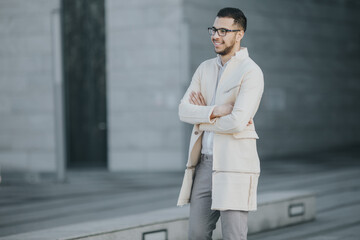 Fototapeta premium Side view of an intern in a fashion industry standing in front of a modern office building