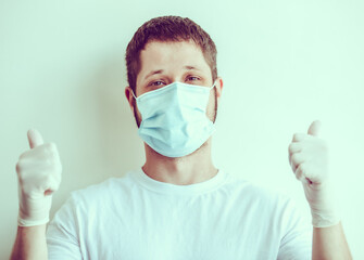 Man in mask and gloves holding thumbs up