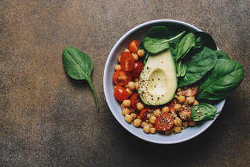 Spinach chickpea salad with avocado and tomatoes. Healthy balanced vegetarian food concept, buddha bowl, vegetable appetizer plate
