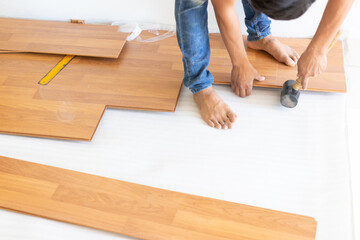 Man installing new laminated wooden floor