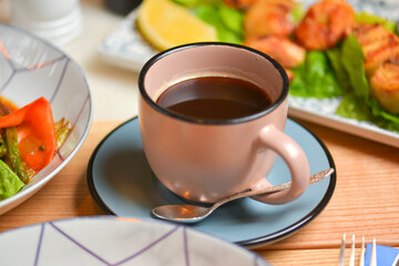 Cup of coffee. Salad with meat and vegetables. Italian cuisine, different dishes served in restaurant.