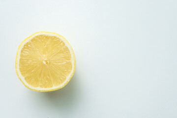 one cut lemon isolated on a white table. view from above