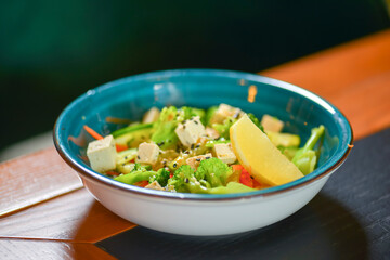 Classic vegetable salad from tomatoes, cucumbers, lemon, red pepper, onion, brocolli, oregano and feta cheese.