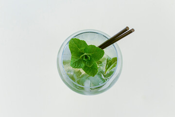 Cold summer alcohol cocktail with ice and orange in a tall wine glass isolated on white background.