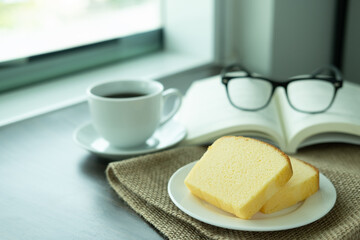 Snacks in the morning break. There are butter cakes, coffee on the table next to the window of the weekend