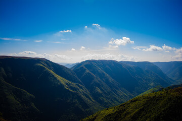 Natural view of the folded mountains and lush green valleys with clear sky and clouds of Cherrapunji, Meghalaya, North East India
