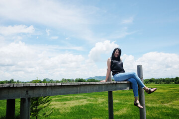 Asian woman sitting on Wooden bridge is freedom and happy on the blue sky. Happiness of life is successful and travel in the world.