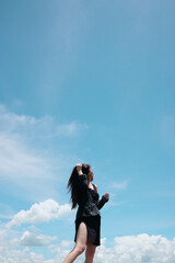 Asian woman long hair standing for freedom and happy in the wind with cloud in the sky. Happiness of life is successful and travel in the world. Copy Space