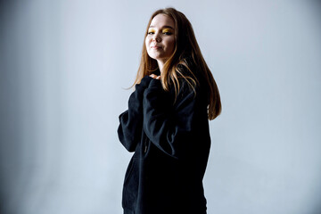 Black sweatshirt on a young woman in shorts, mock up.