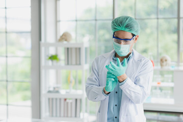 Fototapeta premium Professional Asian scientist or researcher man wearing blue glove before working in science lab. Copy space available