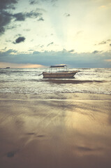 Obraz premium Boat at a tropical beach at sunset, color toning applied.
